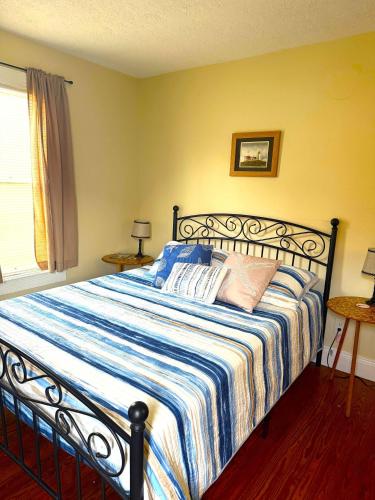 a bedroom with a bed with a blue and white striped blanket at The Riverstone Getaway in historical Madison, IN in Madison