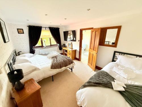 a bedroom with two beds and a window at 6 Bedroom 4 bathroom House 14 guests or more in Birmingham, Wolverhampton, Walsall Contractors, Family & Groups in Walsall