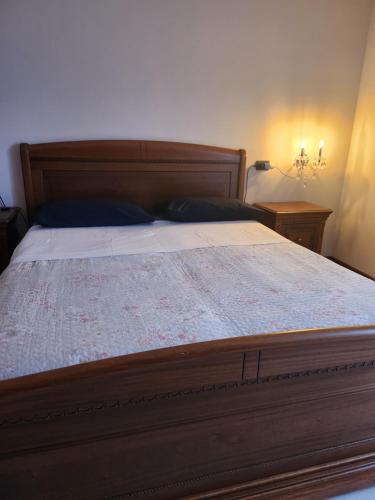a bedroom with a large bed with a wooden headboard at Cerano city house in Cerano