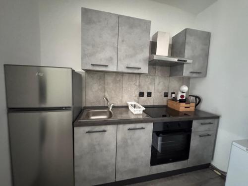 a kitchen with a sink and a stainless steel refrigerator at Bentley Floriana Suites in Il-Furjana
