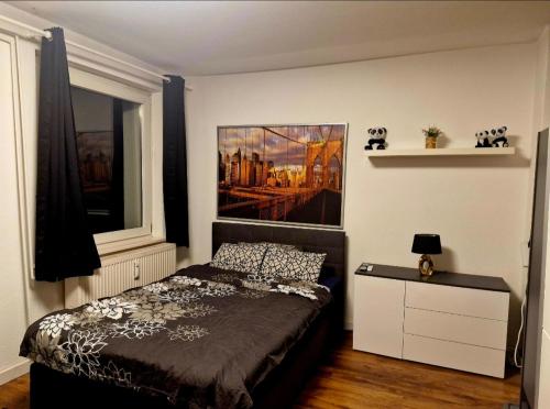 a bedroom with a bed and a painting on the wall at CityNest Hannover O15 in Hannover