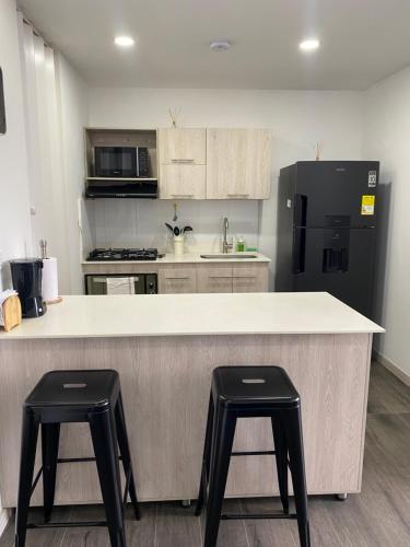 a kitchen with a large counter with two stools at Class 48 Exclusivo y elegante apartamento in Sabaneta