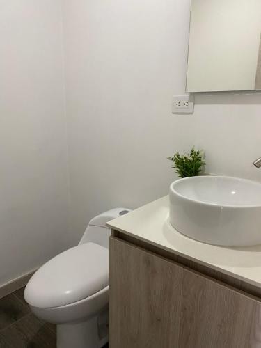 a white bathroom with a toilet and a sink at Class 48 Exclusivo y elegante apartamento in Sabaneta
