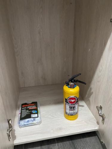 a yellow fire extinguisher sitting on a shelf in a room at Class 48 Exclusivo y elegante apartamento in Sabaneta