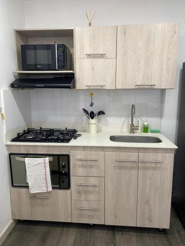 a kitchen with a stove and a sink and a microwave at Class 48 Exclusivo y elegante apartamento in Sabaneta