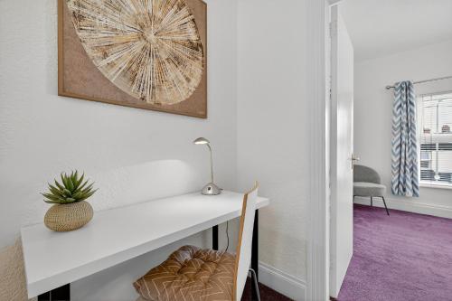 a white desk with a plant on a wall at 3 Bedroom House, Lisburn, 16 minutes to Belfast, Parking in Lisburn