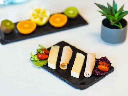 a plate of food with cheese and vegetables on a counter at ibis budget Paris Porte de Vanves in Vanves