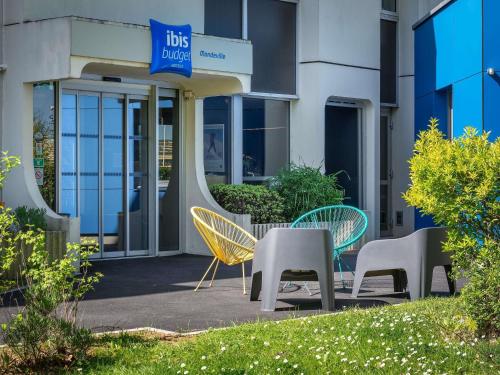 a group of chairs and tables in front of a building at ibis budget Caen Mondeville in Mondeville