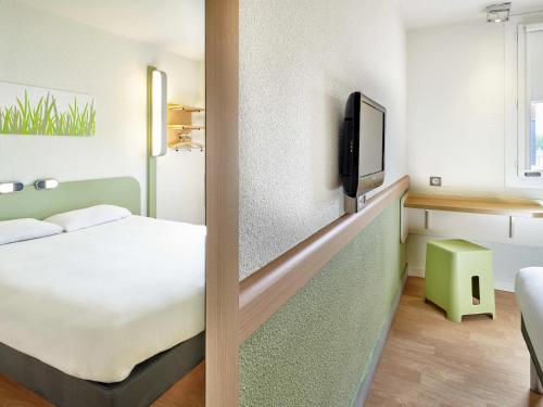 a hotel room with a bed and a tv at ibis budget Saint Paul Les Dax in Saint-Paul-lès-Dax
