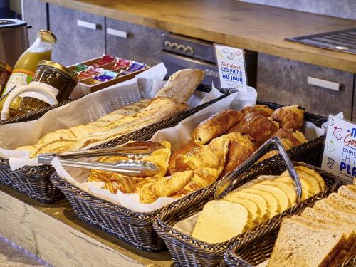 a display of bread and pastries in baskets on a counter at ibis budget Saint Paul Les Dax in Saint-Paul-lès-Dax