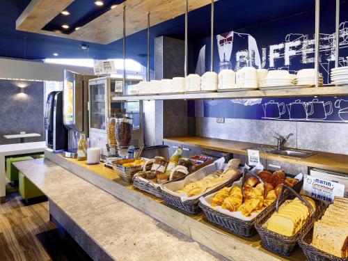 a bakery counter with baskets of bread and other foods at ibis budget Saint Paul Les Dax in Saint-Paul-lès-Dax