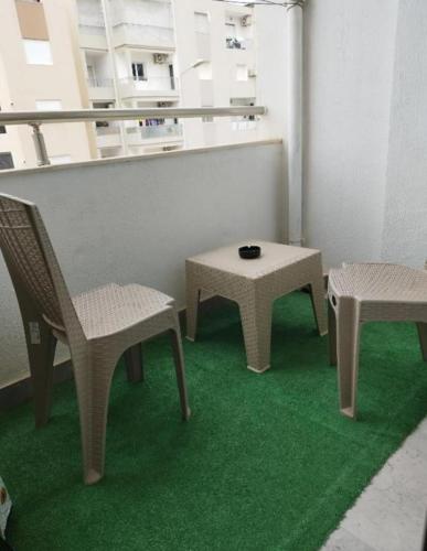a room with two chairs and a table and a table and chairs at Appartement Cosy calme et climatisé avec WIFI Rapide in Boumhel El Bassatine