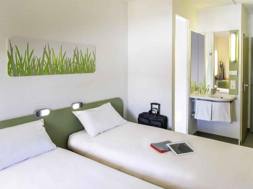 Un dormitorio con dos camas con lavabo y espejo. en ibis budget Vitry sur Seine N7, en Vitry-sur-Seine
