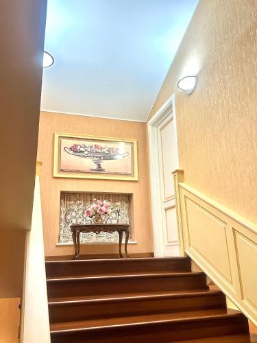 a staircase with a table with flowers on it at Oasi di Monchiero in Monchiero