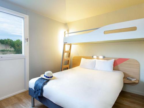 a bedroom with a bunk bed with a hat on it at ibis budget Cavaillon in Cavaillon
