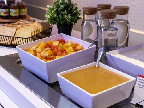 a bowl of fruit and a bowl of honey on a counter at ibis budget Antony Massy rénové 2024 in Antony