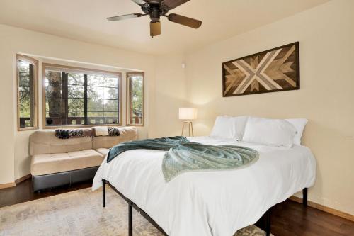a bedroom with a large bed and a couch at Moonridge Treehouse - Relaxing Lofty Big Bear Hillside Retreat- Great Deck Views- Central in Big Bear Lake