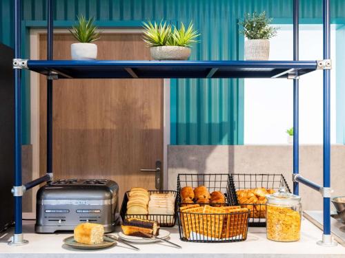 a blue shelf with bread and baskets of food at Ibis budget Béziers Est Mediterranée A9 / A75 in Béziers