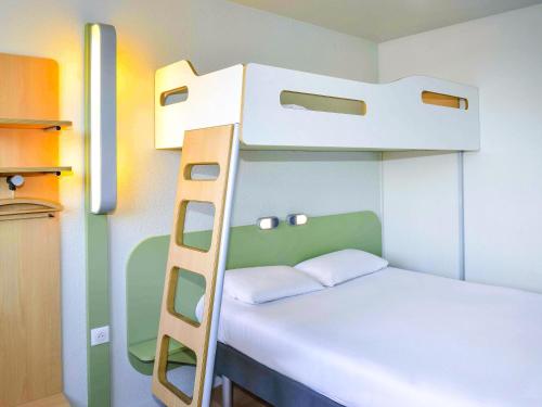 a bunk bed in a small room with a ladder at ibis budget Bordeaux Lac in Bordeaux