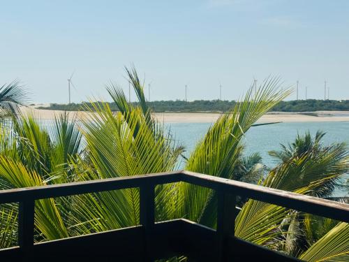 a view of the ocean from a balcony with palm trees at Villa Jaguaribe in Fortim