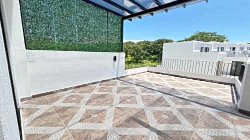a balcony with a white door and a tile floor at Brand New Cow House Aldea Hortus 136 by Kivoya in Naranjo