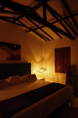 a bedroom with a bed with a light on it at Rustico Hostel Barichara in Barichara