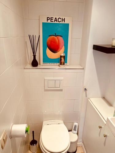 a bathroom with a toilet and a picture of an apple at Antwerp City Nest in Antwerp