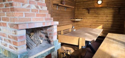 ein Raum mit gemauertem Kamin und einem Tisch und Bänken in der Unterkunft Villa Margarita 1 in Belitsa