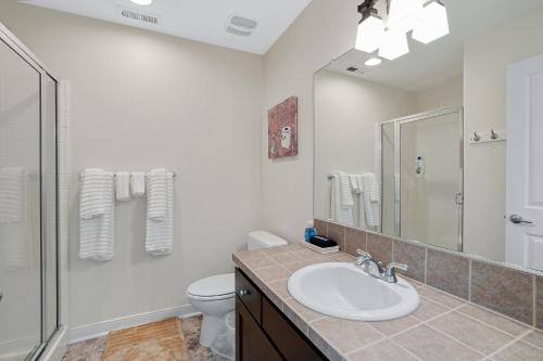 a bathroom with a sink and a toilet and a mirror at Charming Hillsboro Condo with Pool and Gym in Hillsboro