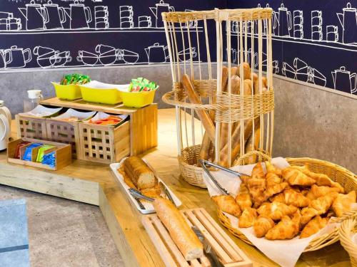a display of bread and pastries on a table at Ibis Budget Saint Malo Centre in Saint Malo