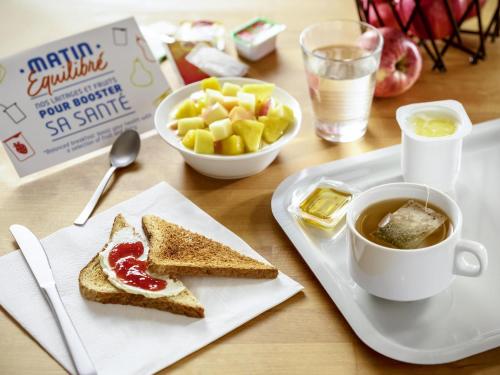 a table with a plate of toast and a cup of coffee at ibis Budget Gennevilliers Asnieres in Gennevilliers