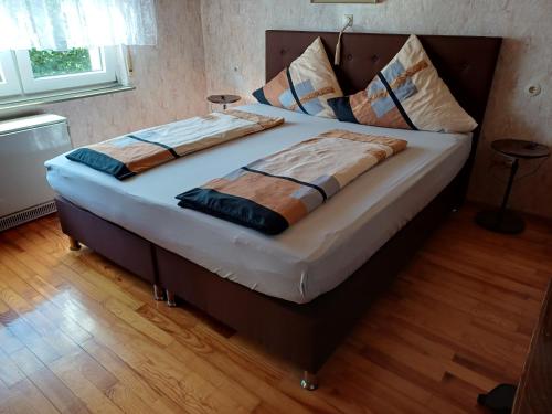 a large bed in a bedroom with a wooden floor at urige gemütliche Ferienwohnung 64 m2 in Dielheim, Nähe Heidelberg in Dielheim