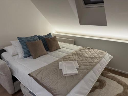 a bed with two towels on it in a room at V&V Sunrise in Neuchâtel