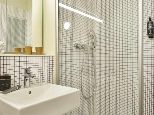 a white bathroom with a sink and a shower at ibis budget Paris Porte d'Aubervilliers in Aubervilliers
