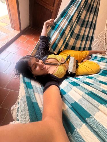 a woman is laying on a bed at Rustico Hostel Barichara in Barichara