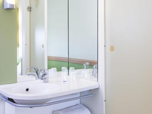 a bathroom with a white sink and a mirror at ibis budget Roissy CDG Paris Nord 2 in Roissy-en-France