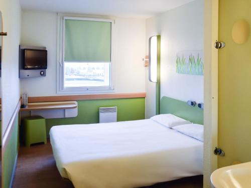 a hotel room with a bed and a sink at ibis budget Roissy CDG Paris Nord 2 in Roissy-en-France