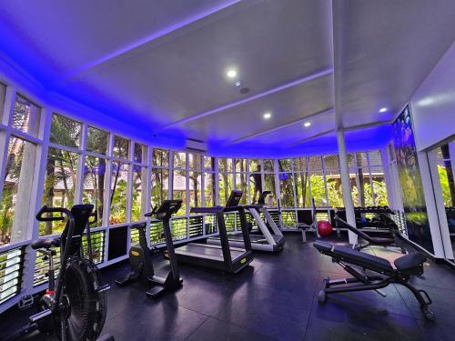 una palestra con tapis roulant ed ellittiche in una stanza con finestre di Tanoa Tusitala Hotel ad Apia