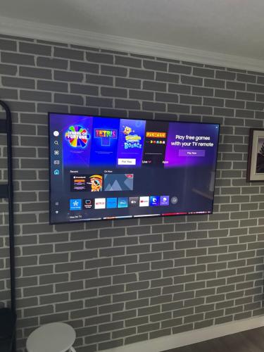 a flat screen tv hanging on a brick wall at Emmas place in Halifax