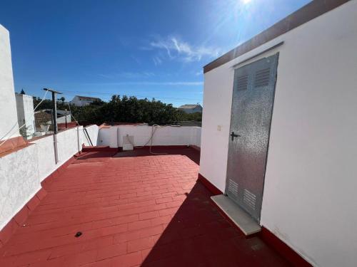 Una pasarela de ladrillos rojos con una puerta en un edificio. en Villa Hogar Espartinas, en Espartinas