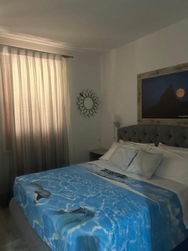 a bedroom with a large bed with a blue blanket at Dolce Dormire in Castiglione del Lago