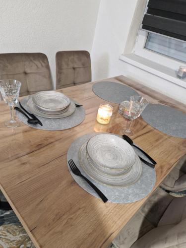 a wooden table with plates and a candle on it at Old Town Maglaj in Maglaj