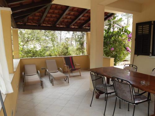 a patio with a wooden table and chairs on a patio at Apartment Deni in Milna