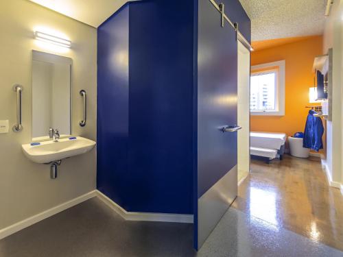 a bathroom with a blue door and a sink at ibis budget Sao Paulo Paraiso in Sao Paulo