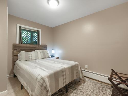 ein weißes Schlafzimmer mit einem Bett und einem Fenster in der Unterkunft Cozy 2BR Mountain Retreat Near Killington Resort - Pet Friendly, Fireplace, Foosball in Sherburne Center