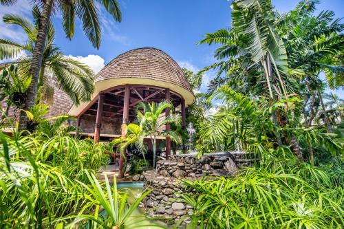 un resort con piscina e un edificio con palme di Tanoa Tusitala Hotel ad Apia