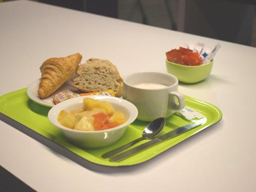 ein grünes Tablett mit einem Teller Essen und einer Tasse Kaffee in der Unterkunft ibis Budget Arles Palais Des Congres in Arles