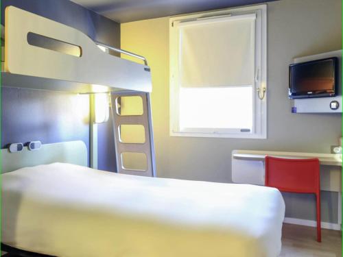 a bedroom with a bunk bed and a red chair at Hotel Ibis Budget Nancy Centre in Nancy