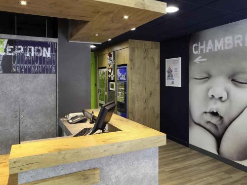 an office with a desk with a picture of a baby at Hotel Ibis Budget Nancy Centre in Nancy