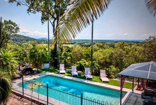 an image of a swimming pool with chairs and trees at Wybalena ocean views tropical big home garden pool in Port Douglas